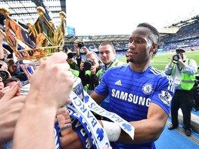 Chelsea's Ivorian striker Didier Drogba (R) shows the Premier League trophy to fans after the presentation following the English Premier League football match between Chelsea and Sunderland at Stamford Bridge in London on May 24, 2015. (AFP)