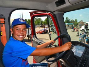 Landon VanderVelde takes the front seat – the catbird seat? - in the West Perth Fire Department's Rescue 1 fire truck during Perth Care for Kids' Big Wheels Little Drivers event at the Mitchell & District Community Centre grounds last Saturday, July 25.  GALEN SIMMONS/MITCHELL ADVOCATE