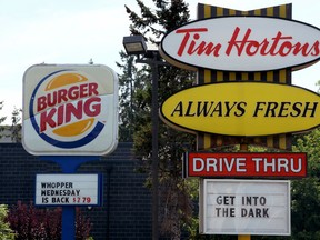 This Aug. 25, 2014, file photo, shows signs for Burger King and Tim Hortons locations in Ottawa, Ontario. (Sean Kilpatrick/The Canadian Press via AP, File)