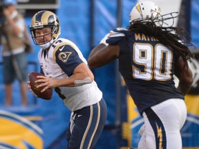 Rams quarterback Shaun Hill (left) is chased out of the pocket by Chargers defensive tackle Ricardo Mathews (right) during NFL action at Qualcomm Stadium in San Diego on Nov. 23, 2014. (Robert Hanashiro/USA TODAY Sports/Files)