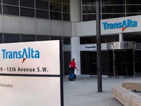 A woman walks towards the entrance of the TransAlta headquarters building in Calgary, on Tuesday, April 29, 2014. The Alberta Utilities Commission has concluded that TransAlta Corp. deliberately timed power outages at power plants at peak times in order to drive up electricity prices. THE CANADIAN PRESS/Larry MacDougal