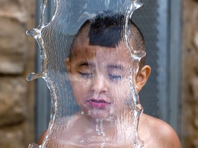 Three year old Treyson Antone cools off at the Ivey Park splash pad in London, Ont. on Monday July 27, 2015. Temperatures in the region will be over very hot all week long. Treyson was visiting the park with his mother Valerie. (DEREK RUTTAN, The London Free Press)