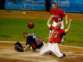 Peter Orr of Canada (left) celebrates after scoring the winning run in extra innings against the U.S. to win the gold medal at the Pan Am Games. (AFP)