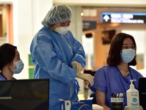 Hospital workers wear face masks at the lobby of Samsung Medical Center in southern Seoul on July 20, 2015. The hospital at the epicenter of South Korea's deadly MERS outbreak started to resume normal operations on July 20, as officials moved closer to declaring a formal end to a crisis that triggered widespread panic and choked the local economy. AFP PHOTO / JUNG YEON-JE