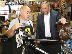 Federal NDP leader Tom Mulcair, right, chats with Don Longarini, owner of the Outside Store in Sudbury, Ont. on Monday July 27, 2015. Mulcair made a stop in Sudbury as part of his Ontario Tour for Change. John Lappa/Sudbury Star/Postmedia Network