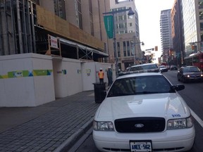 Construction workers and police outside a jobsite along the 100 block of Bank St., on Tuesday morning, after an accident injured three workers. Two were taken to hospital with serious injuries. (DANI-ELLE DUBE Ottawa Sun)