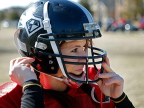In this Feb. 12, 2014, photo, Jen Welter puts her helmet on before the start of the Texas Revolution practice at Bradford Crossing Park in Allen, Texas. The Arizona Cardinals have hired Welter to coach inside linebackers through their upcoming training camp and preseason.(Vernon Bryant/The Dallas Morning News via AP)
