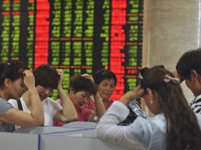Investors react as they look at computer screens showing stock information at a brokerage house in Fuyang, Anhui province, China, July 28, 2015. (REUTERS/Stringer)