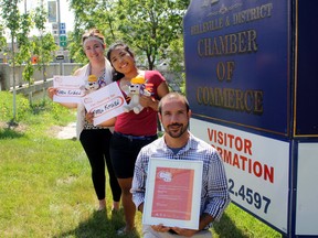 SARAH HYATT/THE INTELLIGENCER
Katlyn Anderson (left), special events assistant for the Belleville and District Chamber of Commerce, and Corrine Codina, a summer student, show off Pachi dolls and cheer cards for the Parapan Am Torch Relay, with Luc Fournier, membership co-ordinator, who's seen here showcasing a thank you certificate from Toronto 2015 for Belleville hosting torch celebrations. The Parapan Am Torch Relay is on Aug. 4.
