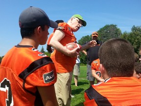 Ottawa-Orléans MP Royal Galipeau has Orléans Bengals players take a knee while he coaches them on the importance of teamwork during a practice at Garneau high school on Tuesday, July 28, 2015. JON WILLING/OTTAWA SUN