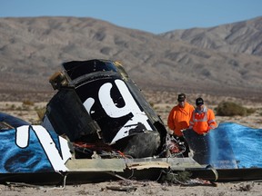 Sheriffs deputies look at wreckage from the crash of Virgin Galactic's SpaceShipTwo near Cantil, California in this November 2, 2014 file photo. (REUTERS/David McNew/Files)