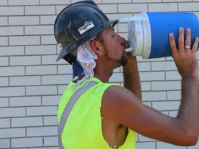 Ryan Williams, 33, of Cobourg Development Services tries to cool off Tuesday afternoon. With the high temperatures this week, construction workers, roofers and other contract workers braved the heat and continued working. In Belleville, Ont. Saturday, May 30, 2015. Samantha Reed/Belleville Intelligencer/Postmedia Network.