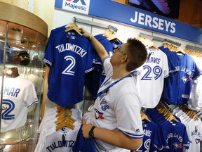 A Blue Jays Pro Shop employee hangs up a Troy Tulowitzki jersey before at the Rogers Centre on Tuesday. Toronto traded Jose Reyes and prospects to Colorado late Monday night for shortstop Tulowitzki and reliever LaTroy Hawkins. (Jack Boland/Toronto Sun)