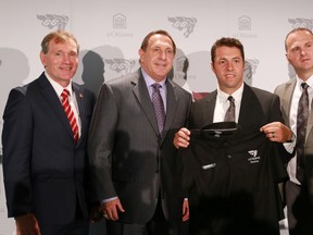 Patrick Grandmaitre (second from right) poses for a photo with Cyril Leeder, left, Jacques Martin and Marc Schryburt after being introduced as the new GeeGees men's hockey coach at the uOttawa sports complex, Wednesday, July 29, 2015.  Mike Carroccetto/Ottawa Sun/Postmedia Network