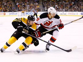 Daniel Paille (left) of the Boston Bruins and Dainius Zubrus of the New Jersey Devils skate to the puck during NHL play April 2, 2013 at TD Garden in Boston. (Jared Wickerham/Getty Images/AFP)