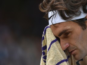 Roger Federer of Switzerland wipes his face with a towel during the men's singles final against Novak Djokovic of Serbia at the All England Lawn Tennis Championships in Wimbledon on July 12, 2015. (Toby Melville/Pool Photo via AP)