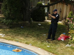 A Toronto Police forensic officer takes images of where an 83-year-old woman was pulled from her pool by Toronto EMS just after noon on Wednesday July 29, 2015 at a home on Meldazy Dr. (Jack Boland/Toronto Sun)