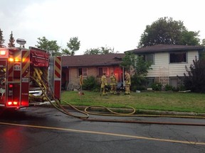 Ottawa firefighters mop up at the scene of an early-morning house fire on Edgecliff Rd. All the residents were able to escape but three firefighters were treated for heat-related ailments at the scene. (DENI-ELLE DUBE Ottawa Sun / Postmedia Network)
