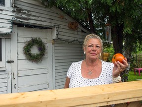 Norma Dunn in front of the shed that's attached to her Parkdale home, where a man broke into and stole tools. He also stole the tomato she holds in her hand. (DANI-ELLE DUBE Ottawa Sun)