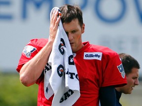 New England Patriots quarterback Tom Brady (12) wipes away sweat during training camp at Gillette Stadium. Winslow Townson-USA TODAY Sports