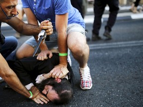 People disarm an Orthodox Jewish assailant after he stabbed and injured six participants at an annual gay pride parade in Jerusalem on Thursday, police and witnesses said July 30, 2015. REUTERS/Amir Cohen