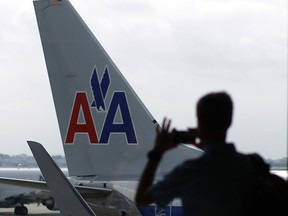 A passenger takes a picture of American Airlines airplanes at a gate at the O'Hare Airport in Chicago, Illinois in this October 2, 2014 file photo. (REUTERS/Jim Young/Files)