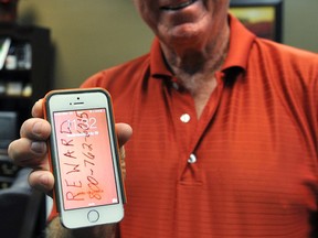 Ben Wilson proudly shows-off his iPhone that survived a 9,300 foot drop from an airplane and landed in a pasture near Joplin, Texas. Wilson said he was able to find his phone using an application that draws a map pointing to the missing device. (Chris Walker/Wichita Falls Times Record News via AP)