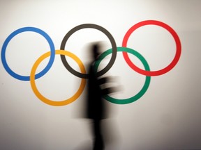 A man walks past the Olympic rings before the opening of the 127th International Olympic Committee (IOC) session in Monaco December 8, 2014.  REUTERS/Eric Gaillard