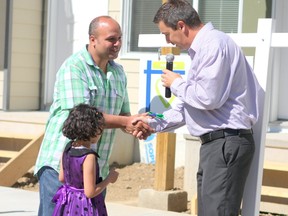 Shereif and his daughter Nour, 5, accept the keys to their new Habitat for Humanity home in Neufeld Landing on Thursday, June 30, 2015. They are one of six families out of 64 that will eventually housedin the development, the largest Habitat for Humanity project in Canada to date. CLAIRE THEOBALD Edmonton Sun.