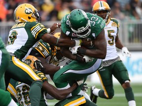 Saskatchewan Roughriders running-back Jerome Messam tries to avoid a tackle from trio of Edmonton Eskimos during the Northern Kickoff pre-season game at SMS Equipment Stadium in Fort McMurray on Saturday June 13, 2015.  Dale MacMillan/Edmonton Sun