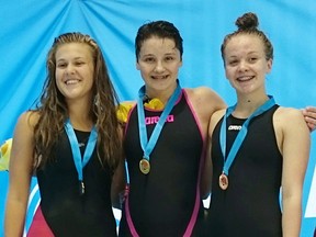 Madison Broad, centre, of the Chatham Y Pool Sharks receives her gold medal for the 14-year-old girls' 50-metre backstroke Thursday at the Canadian age-group swimming championships in Quebec City. (Contributed Photo)