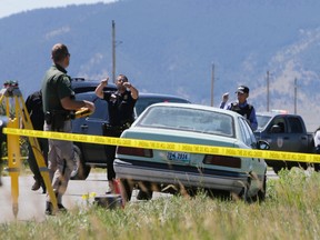 Law enforcement agents investigate the scene of a shooting in Pryor, Mont., on the Crow Reservation on Wednesday, July 29, 2015. (Casey Page/The Billings Gazette via AP)