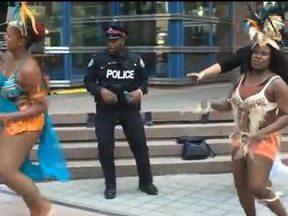 Toronto Police Const. Milton Ferguson dances outside police headquarters during the 24th annual Caribbean Carnival kick-off bash. (framegrab)