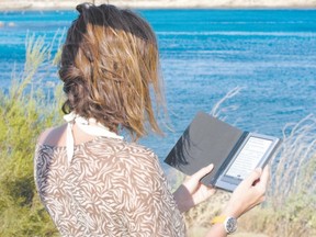 Reading at the beach? You can take precautions to protect your e-reader, or you can do what columnist George Clark does. Take an old-fashioned book. (Fotolia)