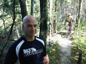 Sean Hickman of Mountain Bike Kingston stands on one of the club's trails in Kingston, Ont. on Friday, July 31, 2015. The club is collecting names on a petition opposed to a solar project that could result in the closure of road allowance cyclists use to connect sections of trail. Elliot Ferguson/Kingston Whig-Standard/Postmedia Network