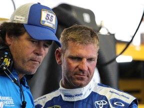Clint Bowyer, driver of the No. 15 Maxwell House Toyota (right) chats with team owner Michael Waltrip in the garage area during practice for the NASCAR Sprint Cup Series Windows 10 400 at Pocono Raceway on Friday. MWR is merging with Chip Ganassi. (AFP/PHOTO)