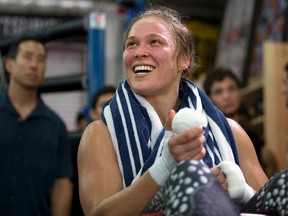 This July 15, 2015, file photo shows mixed martial arts fighter Ronda Rousey smiles during her workout at Glendale Fighting Club, in Glendale, Calif.  Rousey's star power grows with each month, and the UFC's dominant bantamweight champion could have held her next title defense anywhere. She chose to travel to Bethe Correia's native Brazil for UFC 190 on Saturday, Aug. 1 just so she can embarrass the challenger in front of her home fans.  (AP Photo/Jae C. Hong, File)