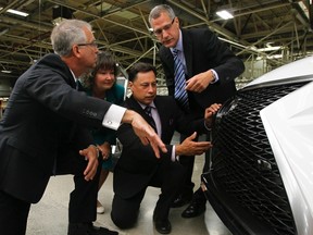 (From left)  Brian Krinock, president of Toyota Motor Manufacturing Inc., Kathryn McGarry, MPP for Cambridge, Ontario Economic Development Minister Brad Duguid, and Gary Goodyear, Minister of State responsible for the Federal Economic Development Agency for Southern Ontario, look at a Lexus SUVat Toyota's plant in Cambridge. (THE CANADIAN PRESS)