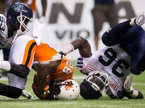 Toronto Argonauts' Brian Rolle, right, falls to the ground after tackling B.C. Lions' Alex Tillman on July 24. (THE CANADIAN PRESS/Darryl Dyck)