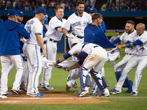 Toronto Blue Jays third baseman Josh Donaldson (20) and shortstop Ryan Goins (17) and centre fielder Kevin Pillar (11) celebrate the win during the eleventh inning in a game against the Kansas City Royals at Rogers Centre. The Toronto Blue Jays won 7-6. (Nick Turchiaro-USA TODAY Sports)