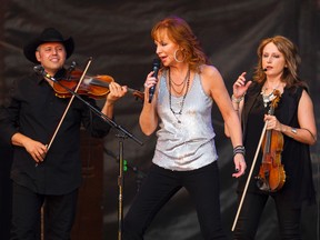 Reba McEntire (centre) performs on the main stage during Big Valley Jamboree 2015 in Camrose, Alta. on Friday July 31, 2015. Ian Kucerak/Edmonton Sun/Postmedia Network