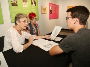 Budding artist Mahlon Bast, right, speaks with For Better or For Worse comic artist Lynn Johnston, left, as local graphic and digital artist Dani Taillefer looks on during Portfolio Day with Lynn Johnston at the Art Gallery of Sudbury in Sudbury, Ont. on Friday July 31, 2015. The event was held for young and emerging artists to meet with both artists to receive feedback and a critique of their work. An exhibition of Lynn Johnston's comic art is on display at the art gallery until Nov. 1. John Lappa/Sudbury Star/Postmedia Network