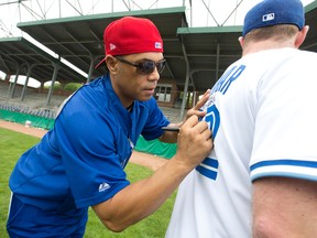 Toronto Blue Jays alumni Roberto Alomar signs a jersey at the Jays Care Foundation's Roberto Alomar and Friends Charity Home Run Challenge at Labatt Memorial Park in London, Ont. on Tuesday June 23, 2015. (Craig Glover/The London Free Press)