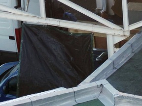 A French gendarme (top partially hidden) works on a oversized crate in the cargo area of the airport in Saint-Denis on the French Indian Ocean island of La Reunion, July 31, 2015. A flaperon, which helps pilots control an aircraft in flight, is to be shipped to France where authorities will analyze the plane debris found on Reunion Island to determine whether it came from Malaysia Airlines Flight MH370 which disappeared without a trace 16 months ago with 239 passengers and crew on board. (REUTERS/Zinfos974/Prisca Bigot)