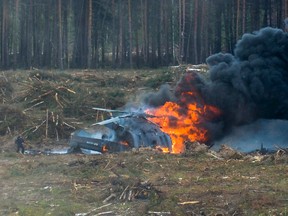 A Russian military helicopter burns after crashing during an aerobatic display in Dubrovichi, Russia, on Aug. 2, 2015, killing one of its crew members and injuring another. (Anton Nasonov, RZN.info/Photo via AP)