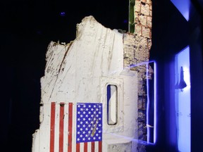 In this Tuesday, July 21, 2015, photo, the left side body panel of space shuttle Challenger is displayed in a glass case at  the "Forever Remembered" exhibit at the Kennedy Space Center Visitor Complex in Cape Canaveral, Fla. (AP Photo/John Raoux)