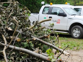 Branches are piled up next to a row of Hydro One trucks in this July 23, 2013 file photo. Storms through southwest and southern Ontario knocked out power to nearly 50,000 Hydro One customers on Aug. 2, 2015. (Clifford Skarstedt/Peterborough Examiner/Postmedia Network File Photo)