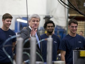 Prime Minister Stephen Harper waves following a demonstration during a campaign stop at Spectra Premium in Laval, Que., on Aug. 3, 2015. (REUTERS/Christinne Muschi)