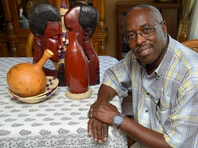 Henri Boyi of London some of the art objects he has from Rwanda. He  has been named one of Canada?s top 25 immigrants. (MORRIS LAMONT, The London Free Press)