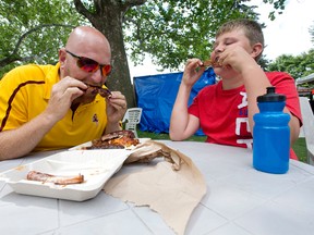 Hubert Vandenberg and his son Gavin, 11, made the trip from Strathroy to enjoy a rack of ribs at Ribfest. (CRAIG GLOVER, The London Free Press)